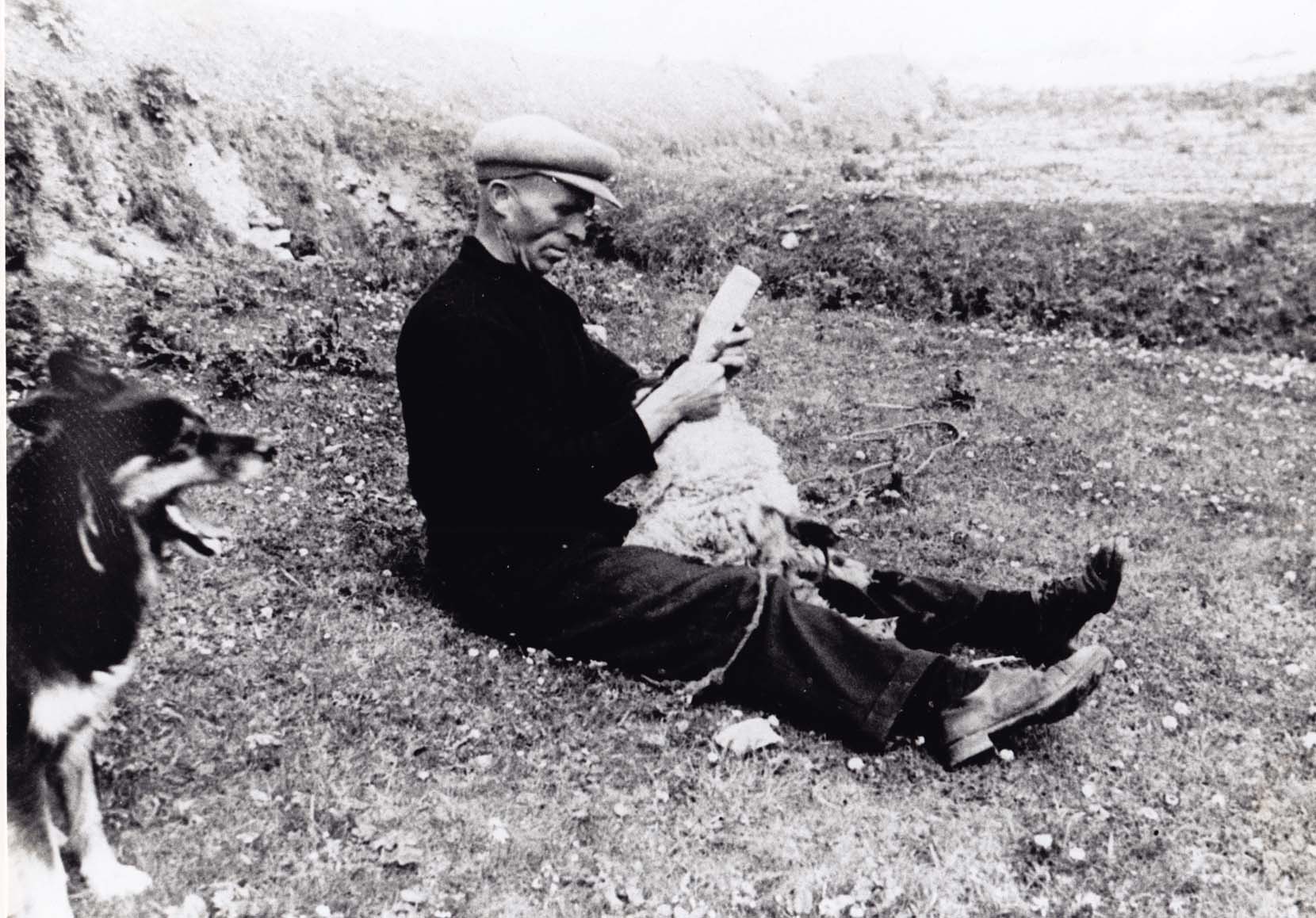 Seán Ó Criomhthain feeding milk to an orphaned lamb.